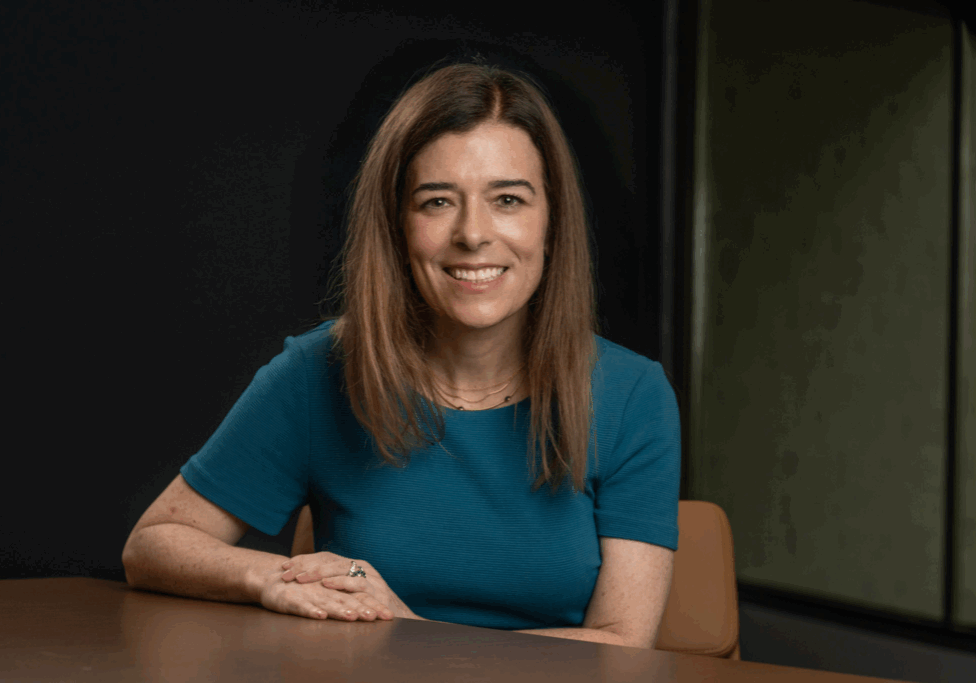 Amy Fogelman, MD, medical expert witness consultant and founder of High Rock Experts, seated at a desk and smiling, wearing a teal top. She provides expert witness training and connects medical professionals with attorneys for legal case support.